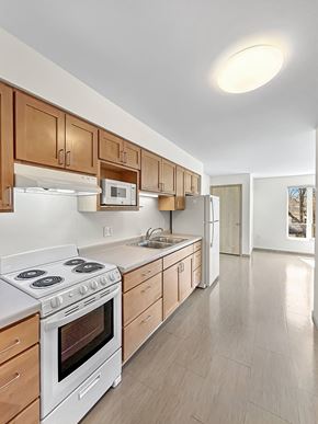 St. Paul apartment for rent - a kitchen with white appliances and wooden cabinets