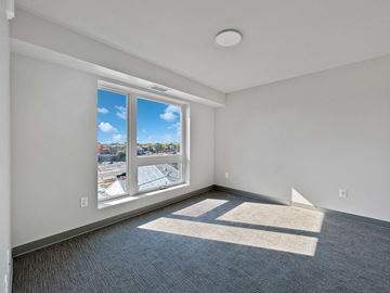 St. Paul apartment for rent - the living room of an apartment with a large window and gray carpet