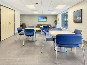 Mankato apartment for rent - A conference room with blue chairs and a television on the wall.