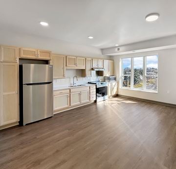 Cottage Grove apartment for rent - A kitchen with wooden cabinets and a stainless steel refrigerator.