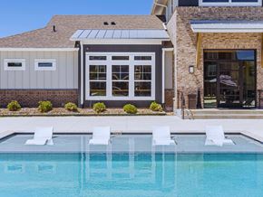 Zachary apartment for rent - a swimming pool in front of a house with a pool and chairs
