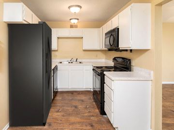 Meridian apartment for rent - a kitchen with white cabinets and a black refrigerator