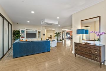 Greer apartment for rent - A blue couch sits in a spacious living room with a wooden floor and a large mirror on the wall.
