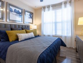 Houston apartment for rent - a bedroom with a bed and windows with blinds