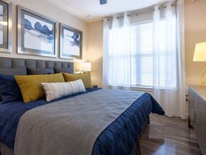 Houston apartment for rent - A bedroom with a bed, pillows, and a lamp.