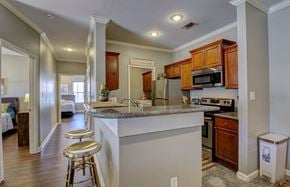 North Little Rock apartment for rent - A kitchen with a white counter top and wooden cabinets.