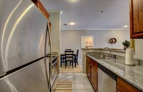 North Little Rock apartment for rent - A kitchen with a stainless steel refrigerator and a dining table with chairs.