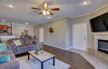 North Little Rock apartment for rent - A living room with a grey couch and a ceiling fan.