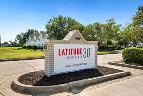 Valdosta apartment for rent - A sign for Latitude 30 Apartments is displayed in front of a building.