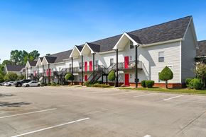Valdosta apartment for rent - A parking lot in front of a building with red doors.