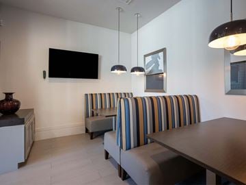 Houston apartment for rent - A living room with a striped couch and a television mounted on the wall.