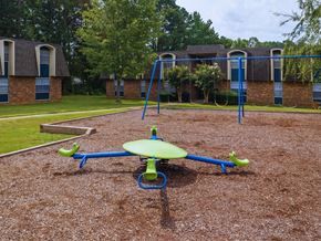 Meridian apartment for rent - a playground with a swing set in front of a building