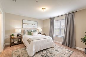 Denham Springs apartment for rent - A bedroom with a large bed and a window with curtains.