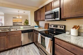 Denham Springs apartment for rent - A kitchen with a black stove top oven and a black microwave above it.