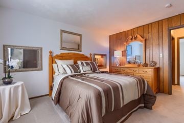 Morgantown apartment for rent - A bedroom with a large bed and a wooden headboard.
