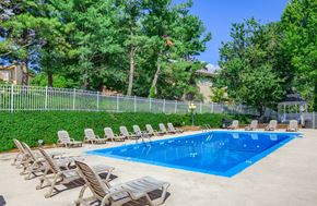 Morgantown apartment for rent - A pool surrounded by chairs and trees.