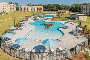 Macon apartment for rent - an aerial view of a large swimming pool with umbrellas and chairs around it