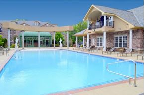 North Little Rock apartment for rent - A large swimming pool in front of a building with a balcony.