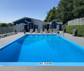 Morgantown apartment for rent - a large swimming pool with lounge chairs and a building in the background