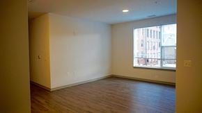 Baltimore apartment for rent - an empty living room with wood floors and a large window