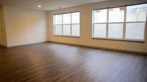 Baltimore apartment for rent - an empty living room with wood floors and large windows