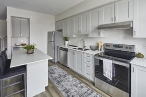 Ottawa townhouse for rent - an open kitchen with white cabinets and stainless steel appliances