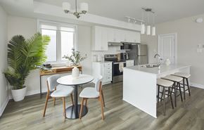 Ottawa apartment for rent - a kitchen with white cabinets and a white table and chairs