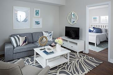 Ottawa apartment for rent - a living room with a gray couch and a white coffee table and a television