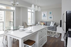 Ottawa apartment for rent - a kitchen and living room with a white island and a glass table