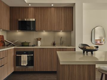 Toronto apartment for rent - A modern kitchen with wooden cabinets and a black oven.