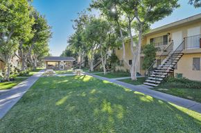 Santee apartment for rent - a yard with grass and trees and a building with stairs
