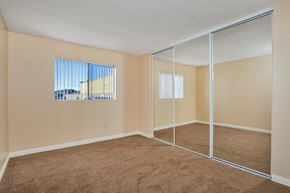 Santee apartment for rent - an empty bedroom with mirrored doors and carpeted flooring