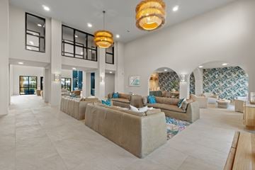 Sarasota townhouse for rent - A spacious living room with a long couch and a chandelier hanging from the ceiling.