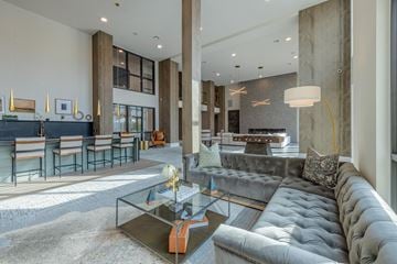 Longmont apartment for rent - A modern living room with a grey sofa and a glass coffee table.