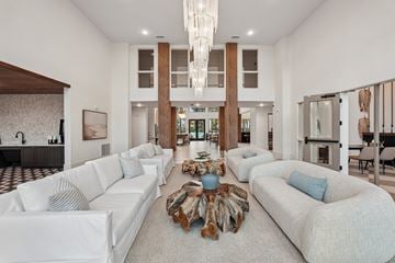 Venice townhouse for rent - A spacious living room with white furniture and a large chandelier.