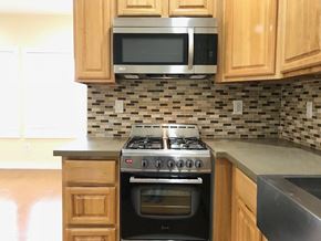 Los Angeles apartment for rent - A kitchen with a stove, oven, microwave, and cabinets.