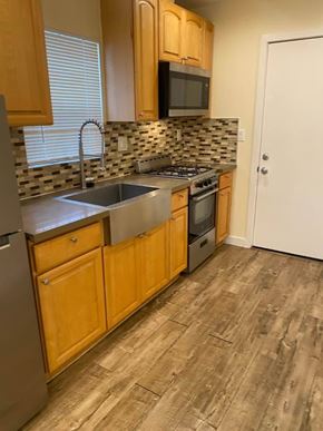 Los Angeles apartment for rent - A kitchen with wooden cabinets and a stove top oven.