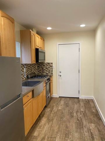 Los Angeles apartment for rent - A kitchen with wooden cabinets and a white door.