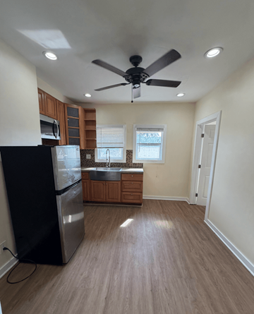Los Angeles apartment for rent - A kitchen with a black fridge and wooden cabinets.