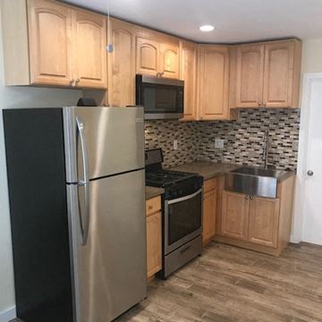 Los Angeles apartment for rent - A kitchen with a stainless steel refrigerator and wooden cabinets.