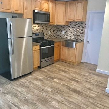 Los Angeles apartment for rent - A kitchen with a stainless steel refrigerator, microwave, oven, and sink.