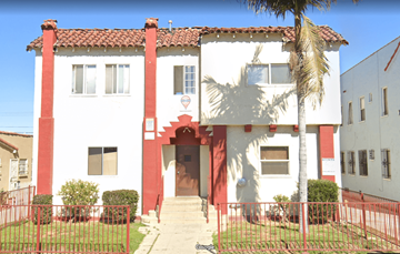 Los Angeles apartment for rent - A red and white building with a palm tree in front.