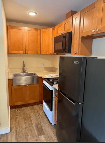 Los Angeles apartment for rent - A kitchen with wooden cabinets and a black refrigerator.