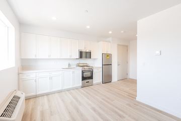 Los Angeles apartment for rent - A kitchen with white cabinets and a stainless steel refrigerator.