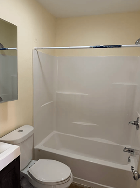 Los Angeles apartment for rent - A white toilet sits next to a white bathtub in a bathroom.