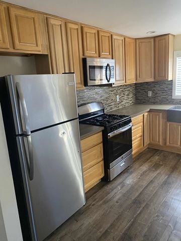Los Angeles apartment for rent - A kitchen with a stainless steel refrigerator and wooden cabinets.
