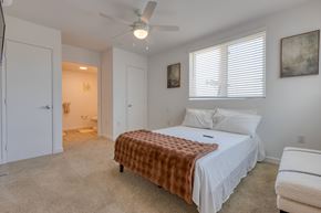 Los Angeles apartment for rent - A bedroom with a bed covered in a brown blanket and a ceiling fan.
