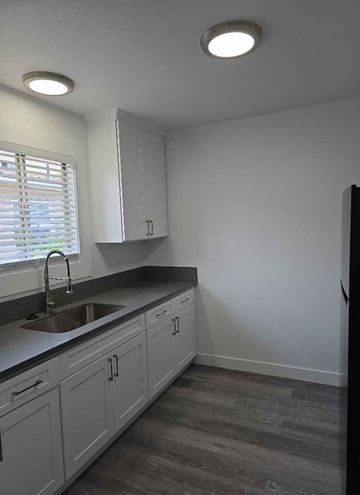 Los Angeles apartment for rent - A kitchen with white cabinets and a sink under a window.