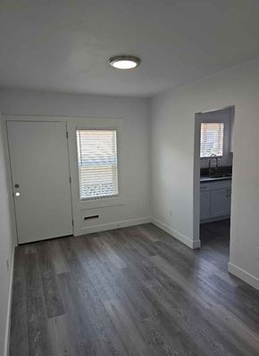 Los Angeles apartment for rent - A room with a wooden floor and a white door.