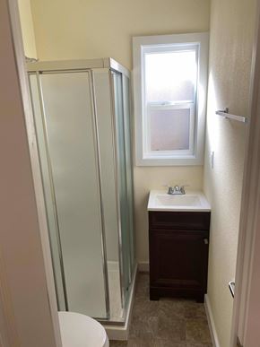 Long Beach apartment for rent - A small bathroom with a toilet, sink, and shower.